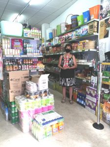 Luisa María en su comercio, con dos paquetes de café cubano envasados como antiguamente, que sigue vendiendo en su negocio