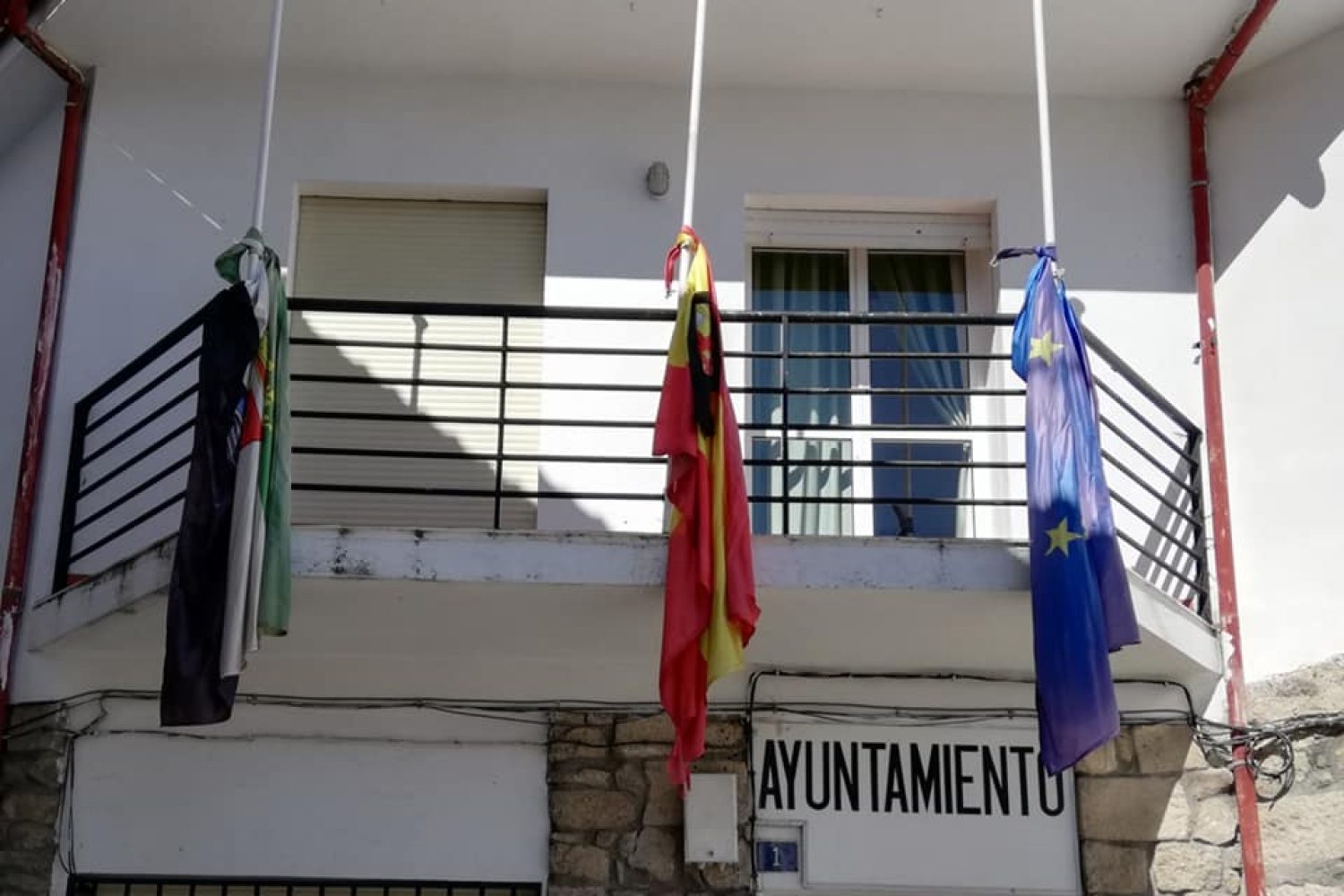 Fachada del ayuntamiento de Cabezabellosa con las banderas a media asta.