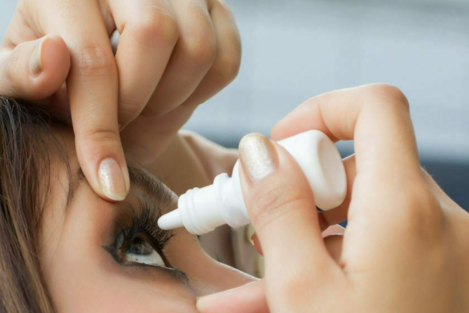 woman using eye drop, eye lubricant to treat dry eye or allergy