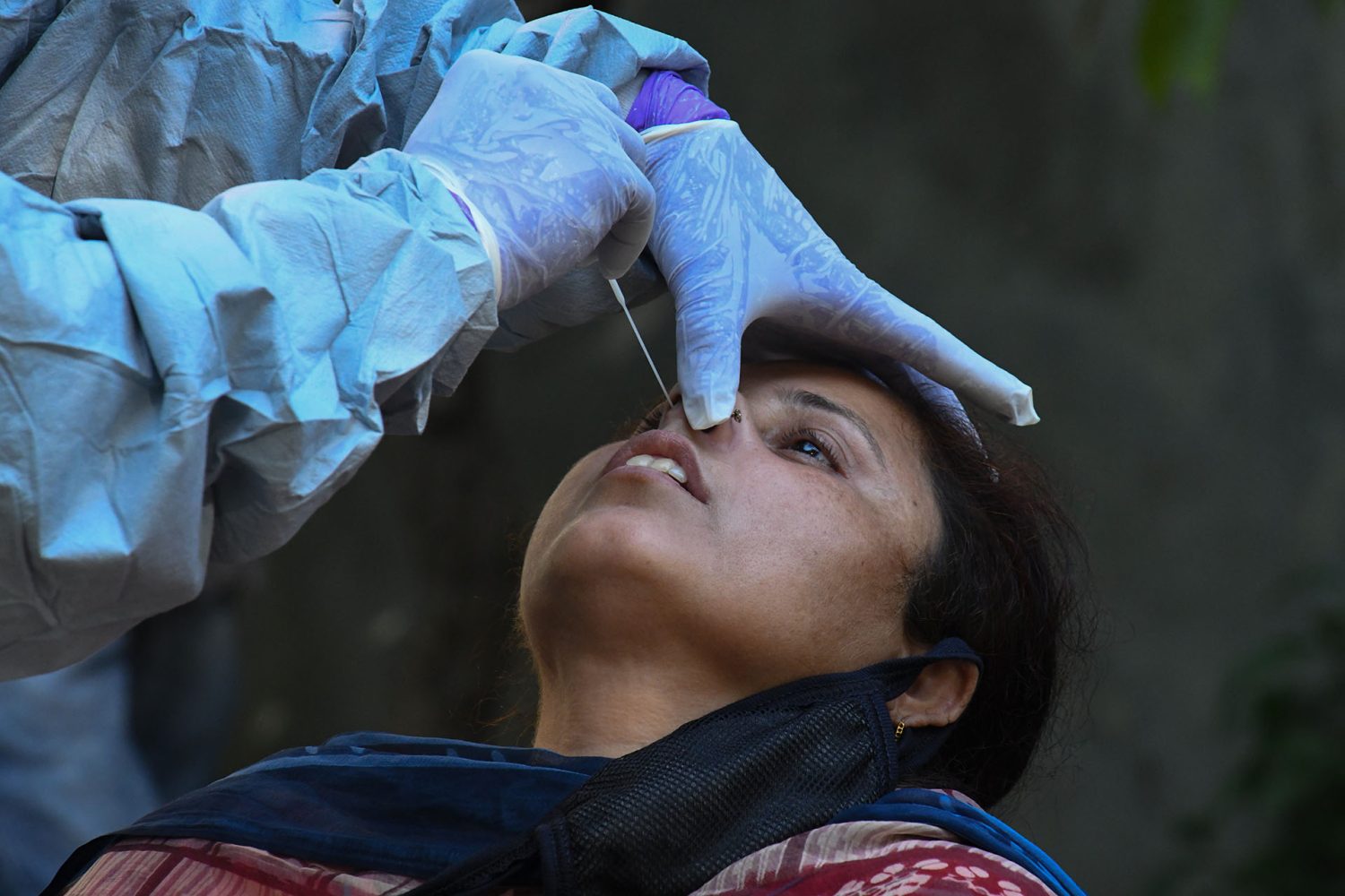 A doctor takes a sample from woman for a RT-PCR COVID-19 test during a government-imposed nationwide lockdown as a preventive measure against the COVID-19 coronavirus, in Amritsar on April 23, 2020. (Photo by NARINDER NANU / AFP)