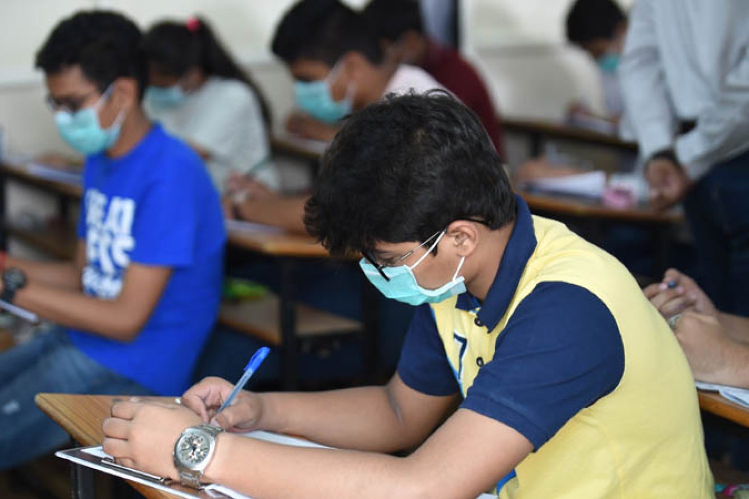 Students sit for the Gujarat Board Xth examination as they wear facemasks provided by the school management at Sadhana Vinay Mandir school, following the COVID-19 coronavirus outbreak, in Ahmedabad on March 5, 2020. - More than 95,000 people have been infected and over 3,200 have died worldwide from the new coronavirus, which by on March 5 had reached some 80 countries and territories. (Photo by SAM PANTHAKY / AFP)