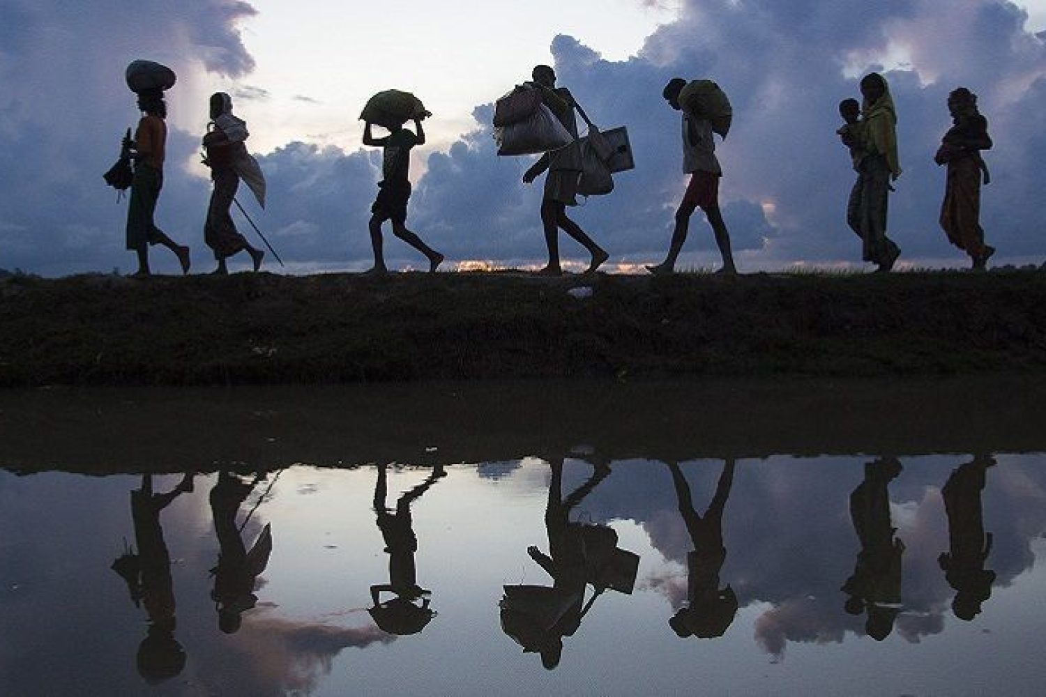 Thousands of new Rohingya refugee arrivals cross the border near Anzuman Para village, Palong Khali, Bangladesh. ; As an estimated 500,000 Rohingya sought safety in Bangladesh between late-August and October 2017, UNHCR worked with the authorities to create a transit centre to prepare for a further influx, as some 11,000 people crossed the border on 9th October. They crossed by land into south-eastern Bangladesh through several points. Many came from the Buthidaung area in Myanmar’s northern Rakhine state. Some said they fled torching and killings. Others said they left in fear ahead of anticipated violence. To reach Bangladesh, they walked for days, many carrying children. They waded through marshland before swimming across the Naf river that divides the two countries. UNHCR worked swiftly to accommodate as many as possible in the camps and settlements in Kutupalong and Balukhali, and provided emergency relief items.
