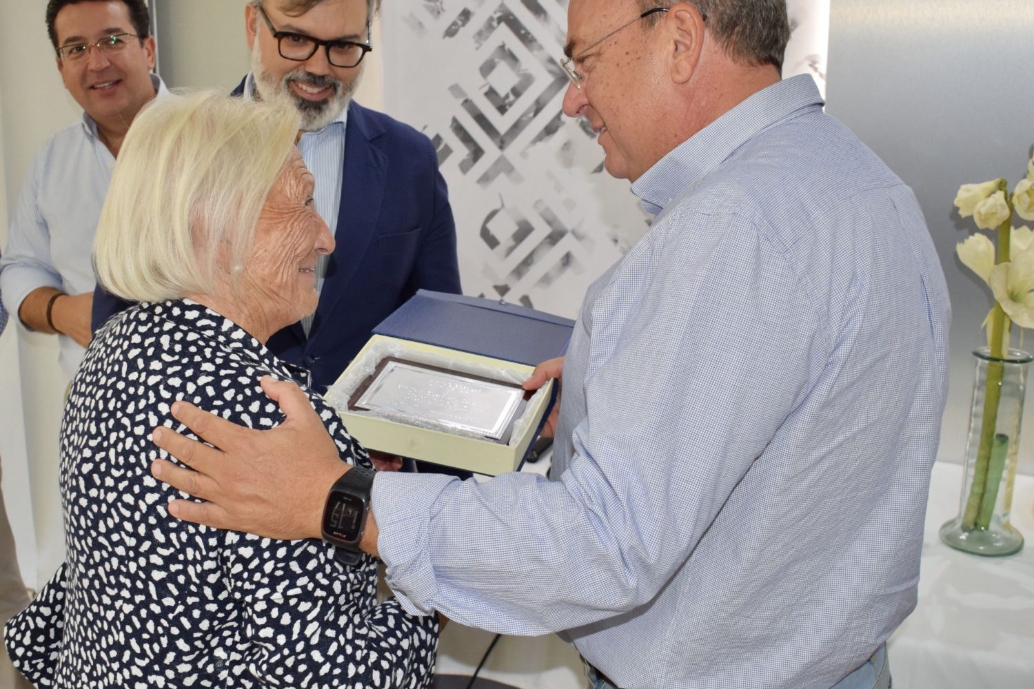 Monago entregando una placa a una afiliada, en presencia de Pizarro.